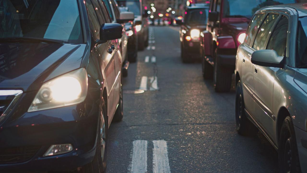 Vehicles driving in lane with headlights on